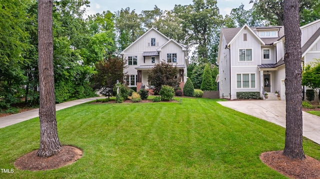 3337 Cheswick Dr, Raleigh, NC 27609 - modern farmhouse style home featuring board and batten siding, a front yard, a standing seam roof, and driveway