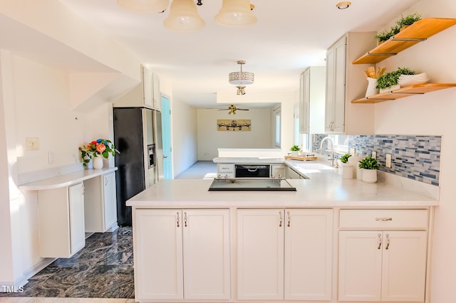 kitchen with a peninsula, open shelves, a sink, light countertops, and refrigerator with ice dispenser