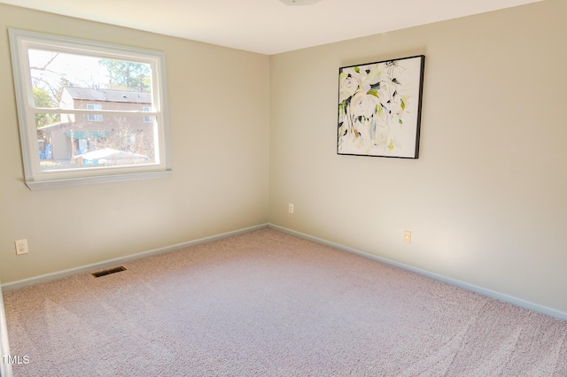 unfurnished room with visible vents, baseboards, and carpet floors