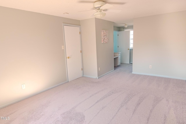 interior space with baseboards, a ceiling fan, and carpet flooring