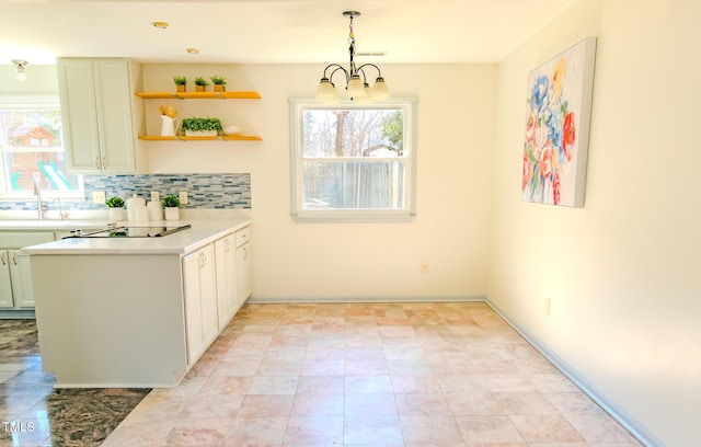 kitchen featuring a wealth of natural light, cooktop, decorative backsplash, and light countertops