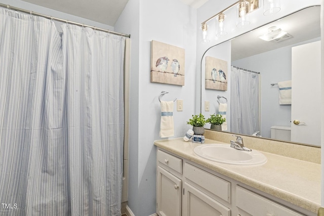 full bathroom with curtained shower, toilet, and vanity