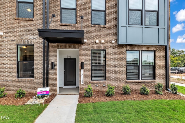 entrance to property featuring brick siding