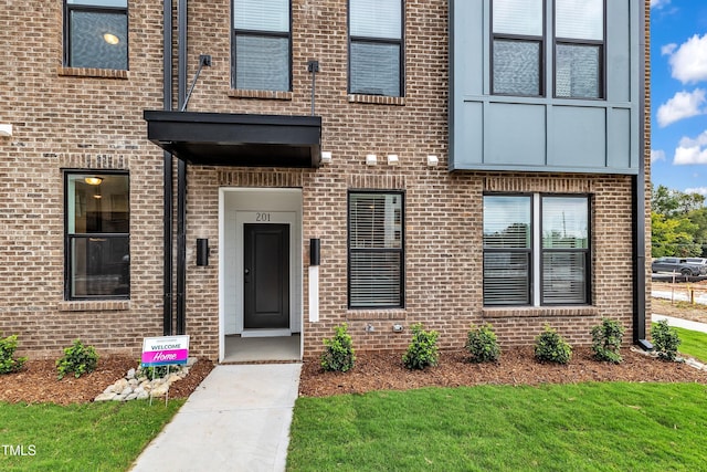 view of exterior entry featuring brick siding