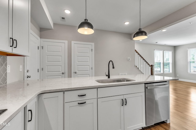 kitchen featuring light stone countertops, visible vents, white cabinetry, a sink, and dishwasher