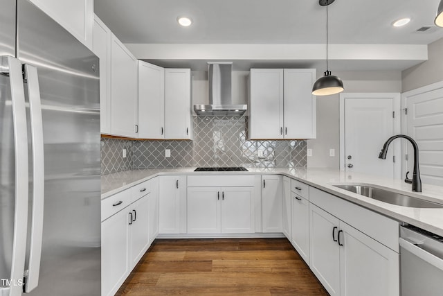 kitchen with visible vents, dark wood-style flooring, a sink, appliances with stainless steel finishes, and wall chimney range hood