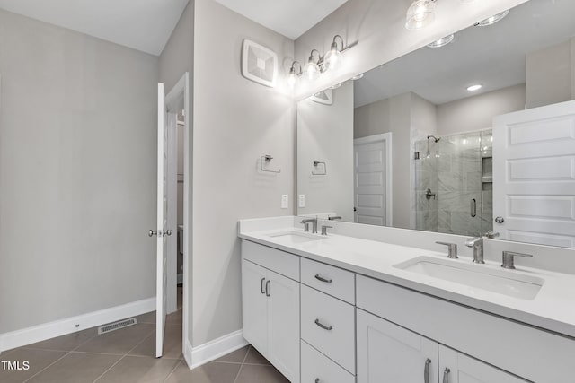 full bath with tile patterned floors, visible vents, a stall shower, and a sink