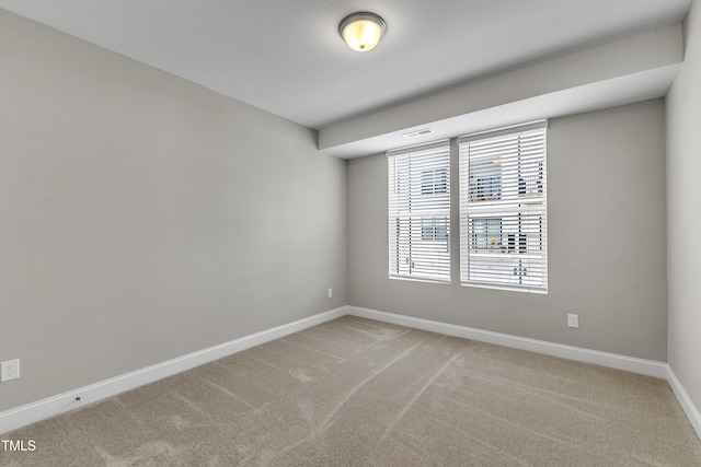 unfurnished room with visible vents, baseboards, and light carpet