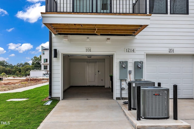 property entrance featuring central air condition unit, a balcony, and a garage