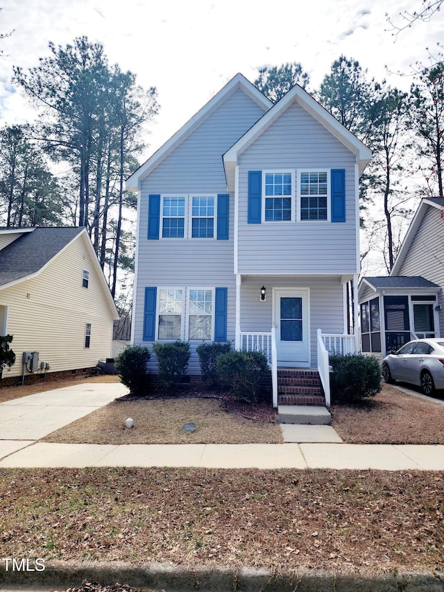 view of front of home featuring covered porch and a sunroom