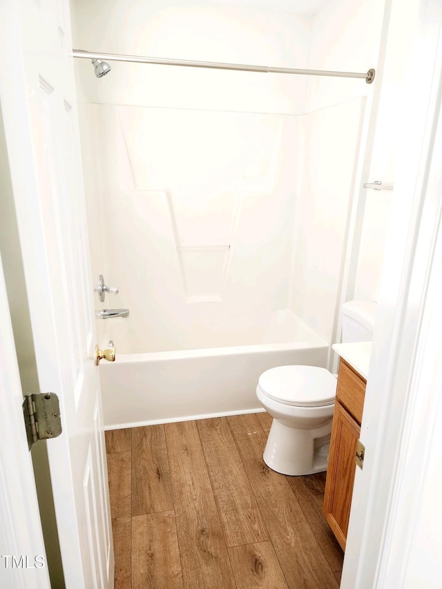 full bath with vanity, shower / tub combination, toilet, and wood finished floors