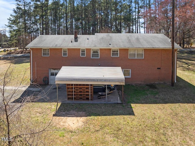 rear view of house with a yard, brick siding, a chimney, and a patio area