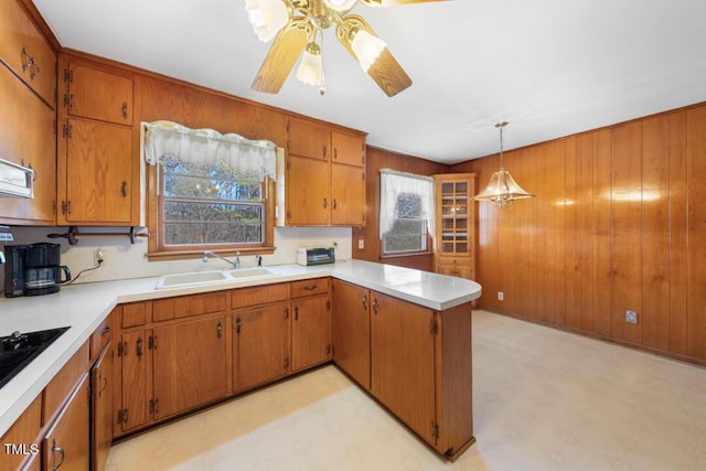 kitchen with a sink, brown cabinets, light floors, and a wealth of natural light