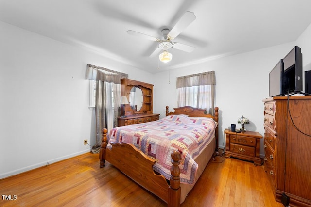 bedroom with ceiling fan, baseboards, and wood finished floors