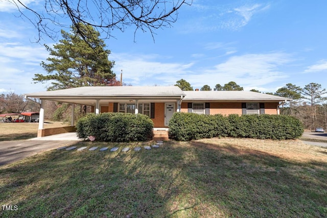 single story home with brick siding, an attached carport, a porch, and a front lawn