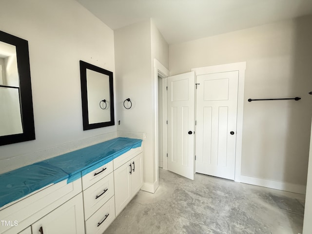 bathroom featuring vanity, concrete flooring, and baseboards