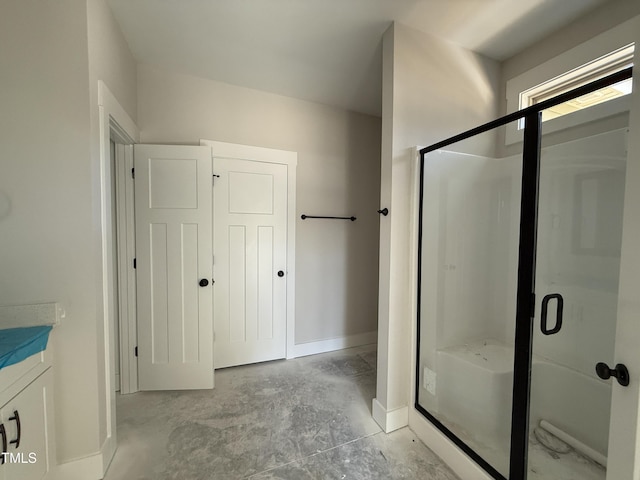 bathroom featuring vanity, unfinished concrete floors, baseboards, and a stall shower