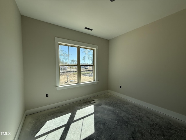 empty room featuring unfinished concrete floors and baseboards