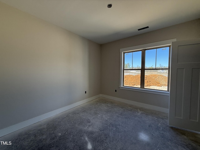 spare room featuring visible vents, baseboards, and unfinished concrete floors