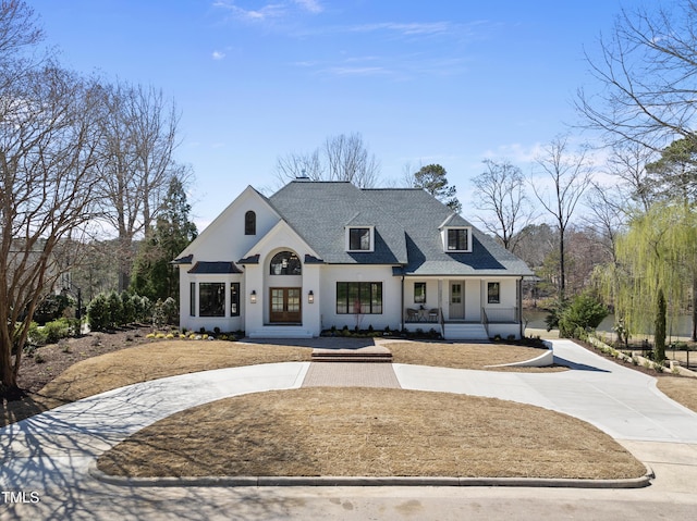 view of front facade with driveway and roof with shingles