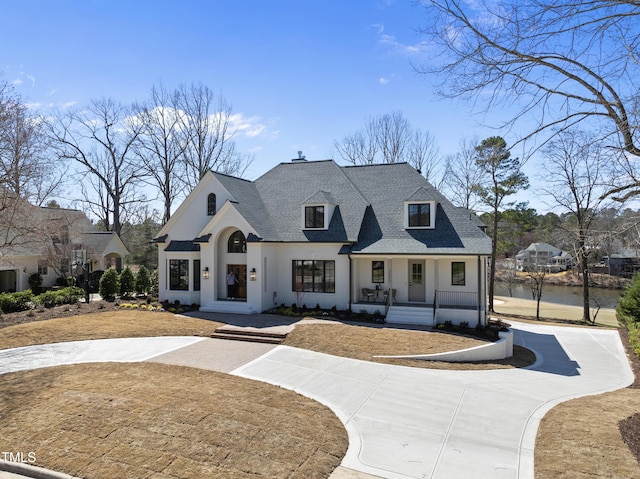 view of front of home with stucco siding, a porch, concrete driveway, and a shingled roof