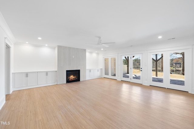 unfurnished living room with crown molding, recessed lighting, a fireplace, and light wood-style floors