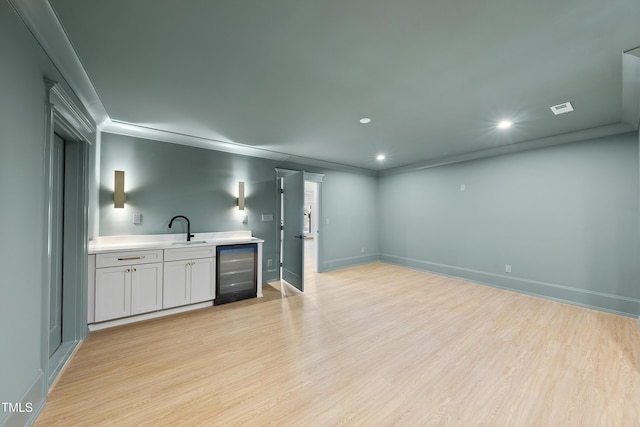 bar featuring beverage cooler, recessed lighting, baseboards, and light wood-style floors