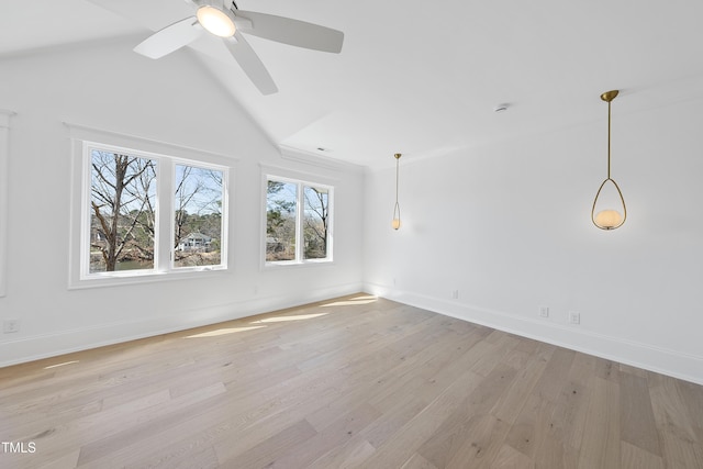 unfurnished room with lofted ceiling, light wood-style flooring, baseboards, and ceiling fan