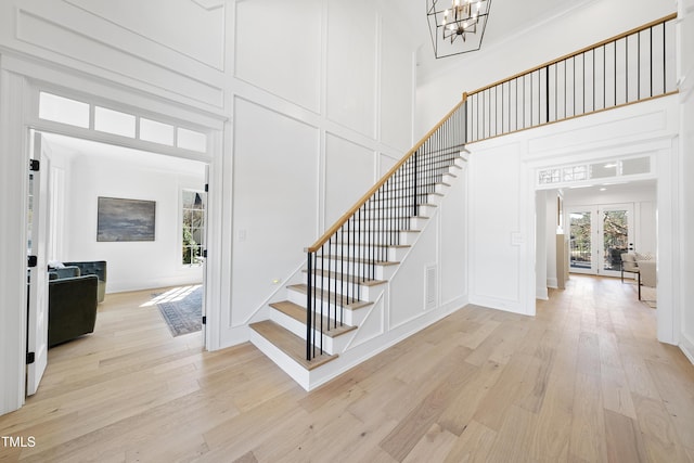 interior space featuring a decorative wall, wood finished floors, visible vents, and a towering ceiling