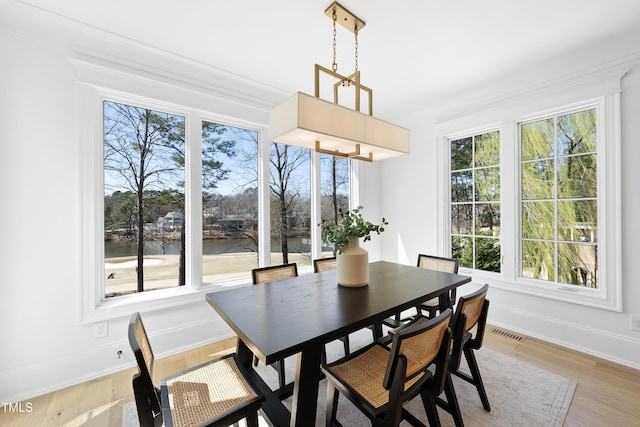 dining room featuring light wood-type flooring, baseboards, and visible vents