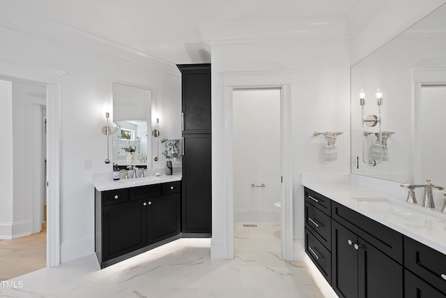 bathroom featuring a sink, marble finish floor, and ornamental molding