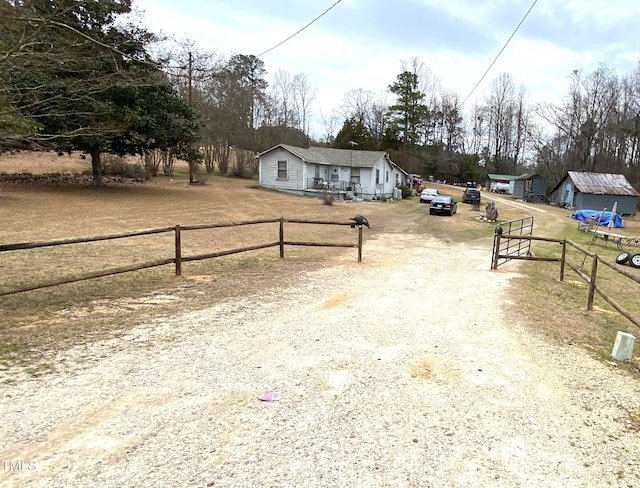 view of front of house featuring a fenced front yard and dirt driveway