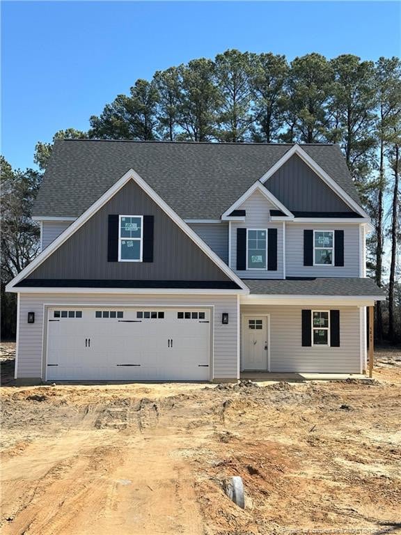 view of front of home featuring an attached garage and dirt driveway