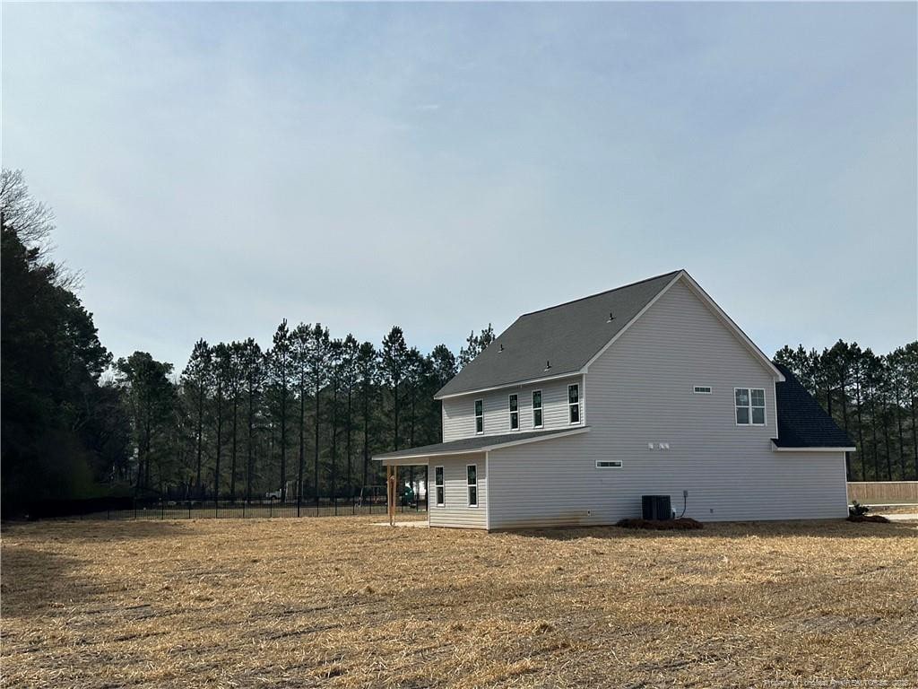 view of home's exterior featuring central air condition unit and fence