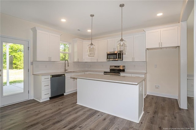 kitchen featuring tasteful backsplash, stainless steel appliances, light countertops, white cabinets, and a sink