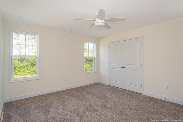 unfurnished bedroom with carpet floors, a closet, baseboards, visible vents, and a ceiling fan