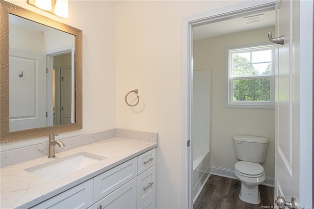 bathroom with visible vents, baseboards, toilet, wood finished floors, and vanity