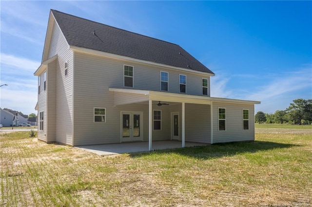 rear view of property featuring a patio, a ceiling fan, a yard, and french doors