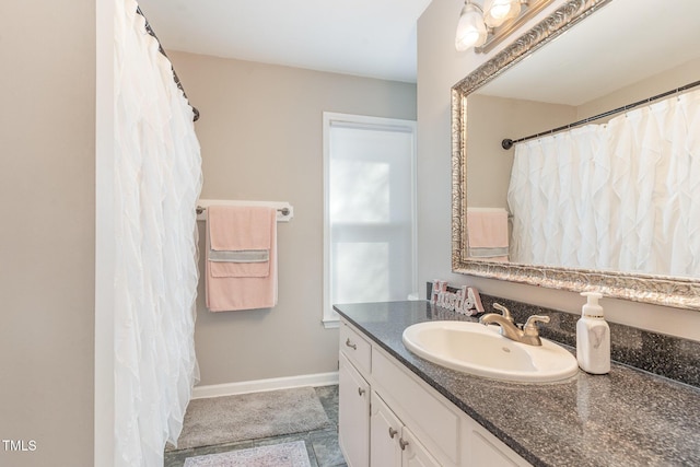 full bathroom with vanity and baseboards