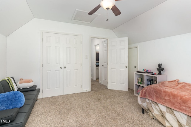 carpeted bedroom with attic access, a ceiling fan, and vaulted ceiling