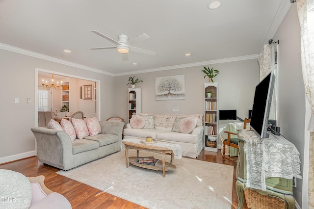 living room with ceiling fan with notable chandelier, recessed lighting, wood finished floors, and ornamental molding