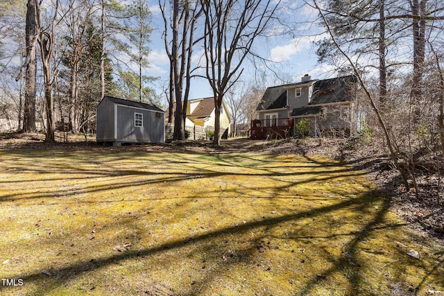 view of yard featuring an outbuilding, a shed, and a wooden deck