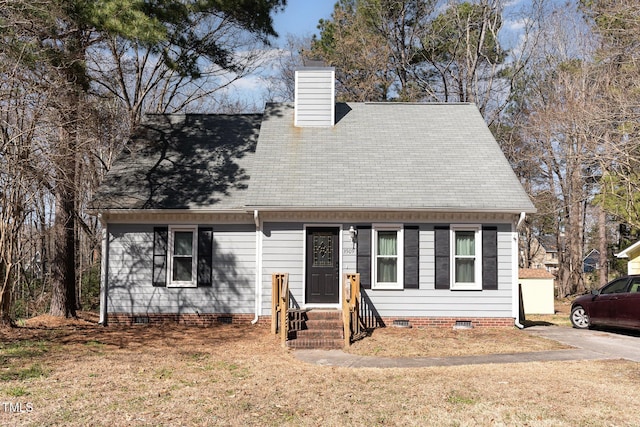 new england style home with crawl space, roof with shingles, and a chimney