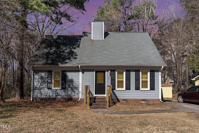 cape cod-style house with crawl space, a chimney, and a shingled roof