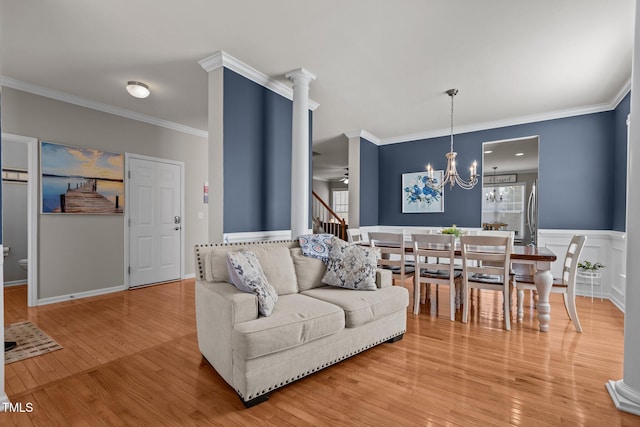 living room featuring crown molding, a notable chandelier, and light wood-type flooring