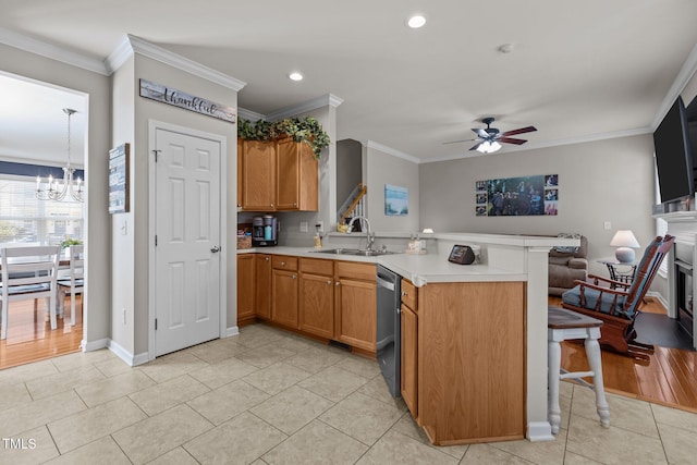 kitchen with a sink, crown molding, ceiling fan with notable chandelier, a peninsula, and stainless steel dishwasher