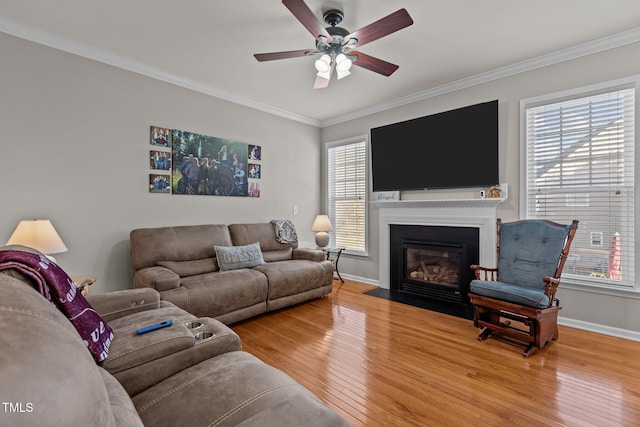 living area with hardwood / wood-style floors, a healthy amount of sunlight, and ornamental molding