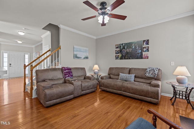 living room featuring stairway, a ceiling fan, wood-type flooring, and ornamental molding