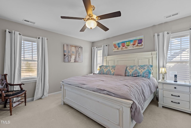 bedroom featuring multiple windows, light colored carpet, and visible vents