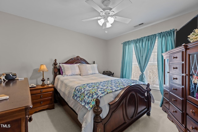 bedroom featuring visible vents, light carpet, and a ceiling fan